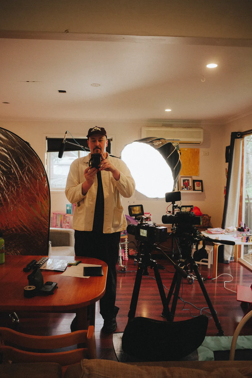 Lucky Boy setting up a two-camera interview with a softbox in the lounge room before the renovation