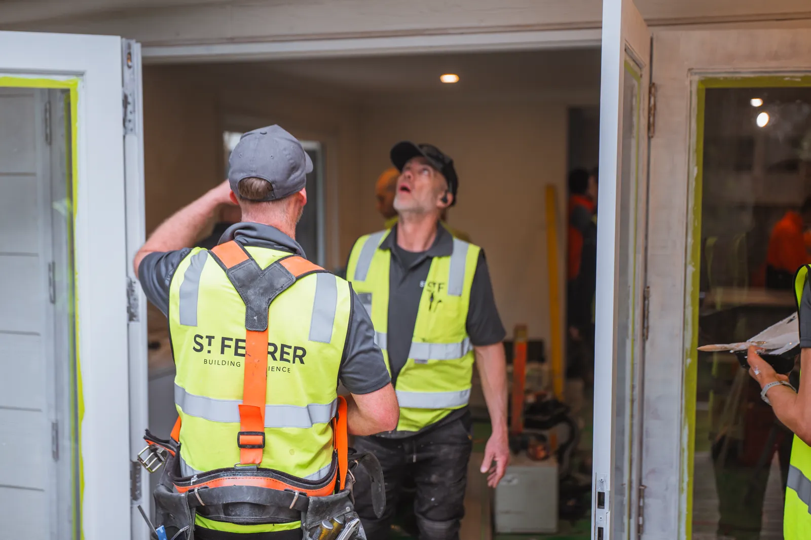 St Ferrer crew in hi-vis looking up at the work inside the doorway