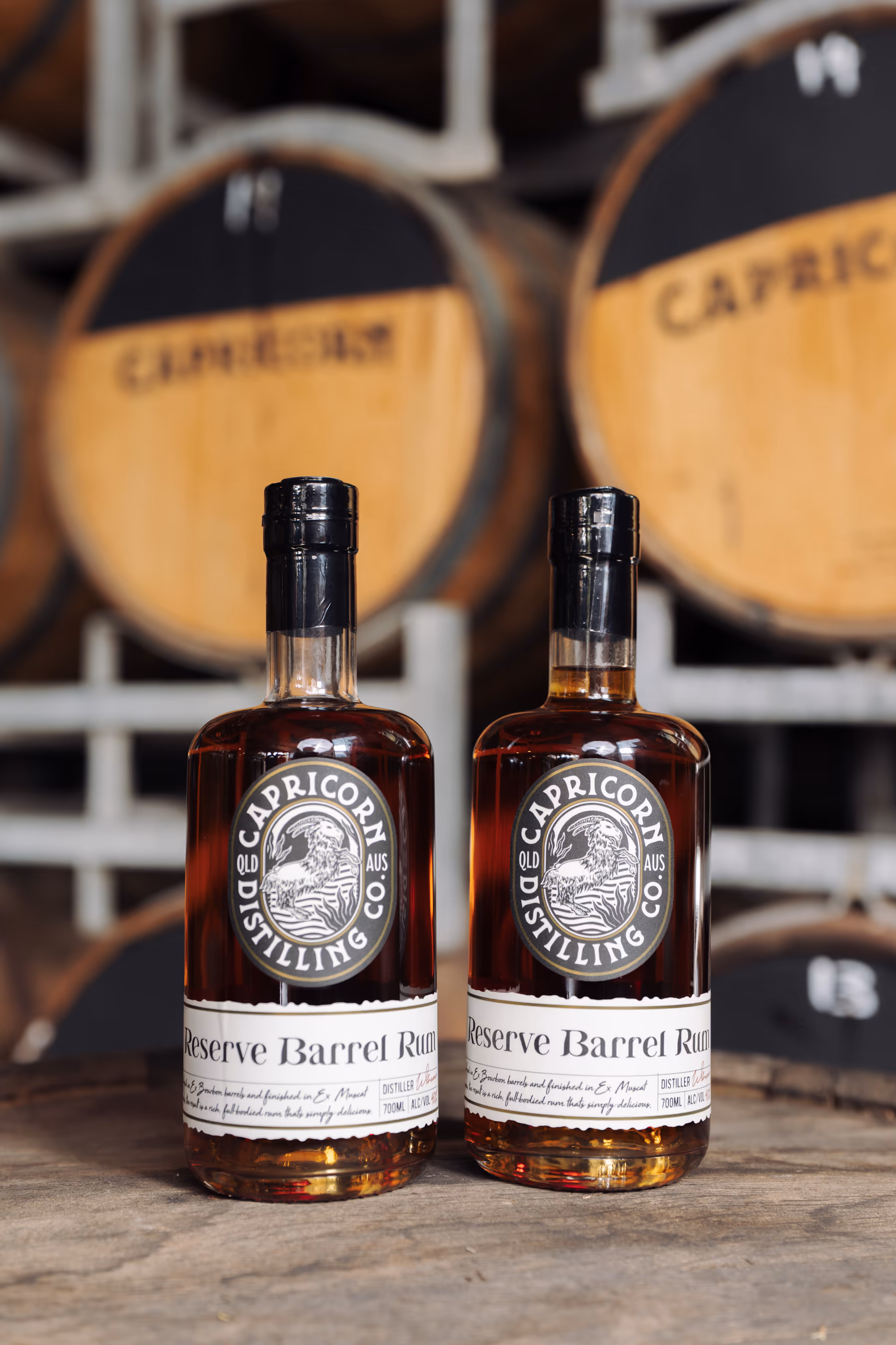 Two bottles of Capricorn Reserve Barrel Rum on a barrel head in the barrel store