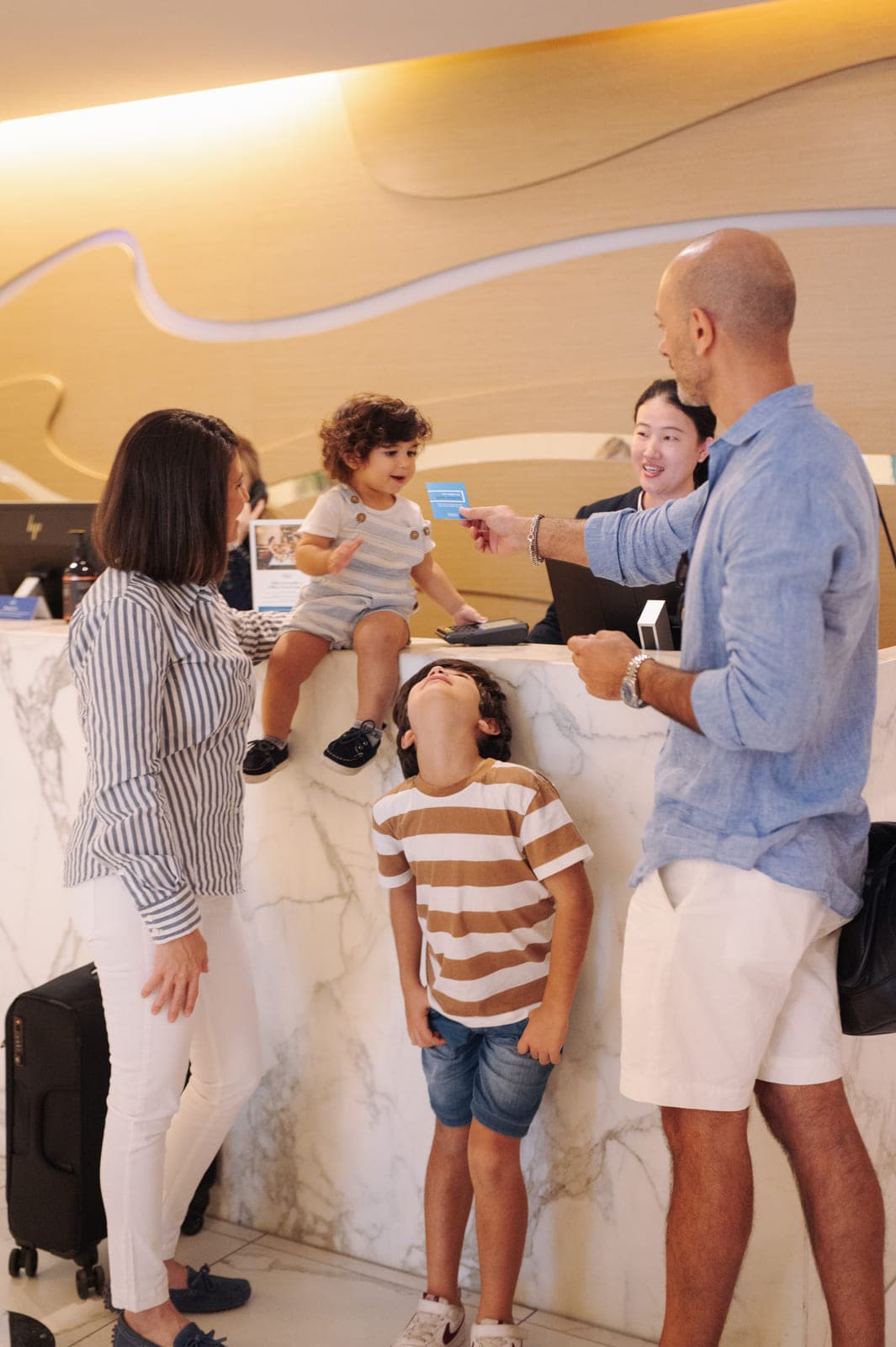 A family arriving at Hilton Surfers Paradise, luggage beside the bed