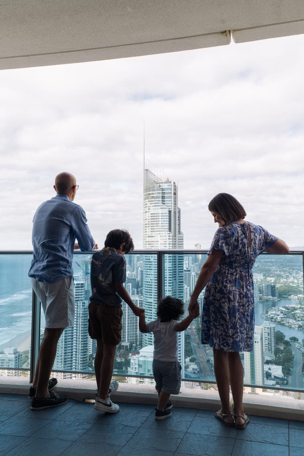 A family on a Hilton Surfers Paradise balcony looking over the Gold Coast skyline